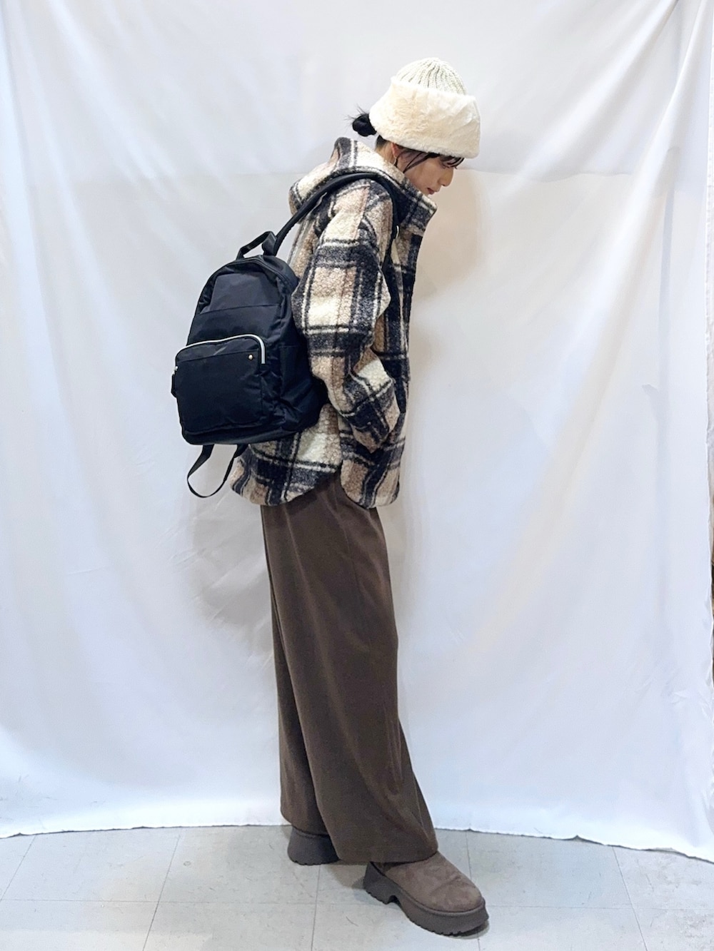 ブラウン系のその他アウター、オレンジ系のニット/セーター、ブラウン系のその他パンツを着用したレディースの秋コーディネートの2枚目の写真