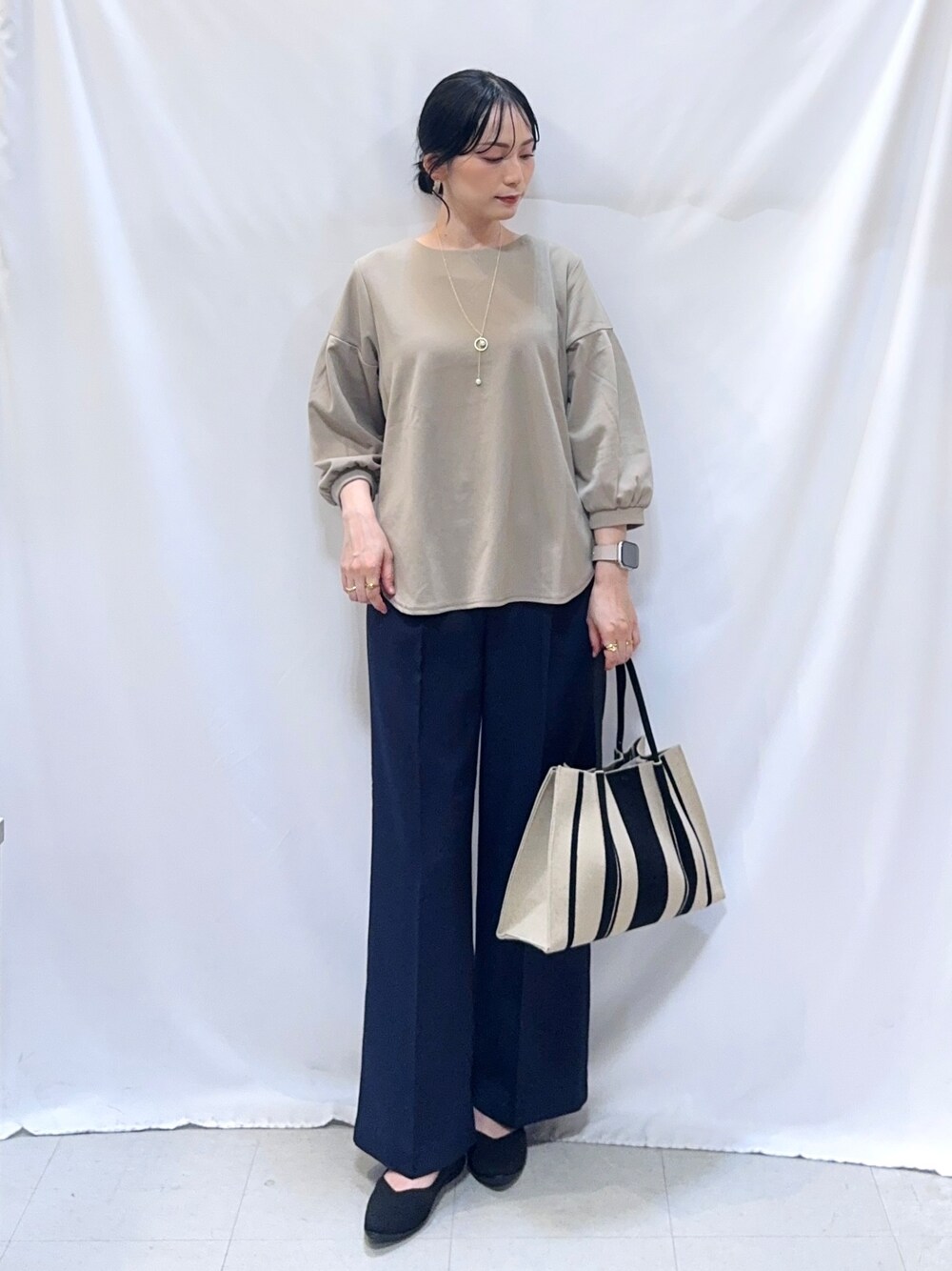 ブルー系のその他パンツ、ブラック系のパンプス、ブラック系のトートバッグを着用したレディースの秋コーディネートの2枚目の写真