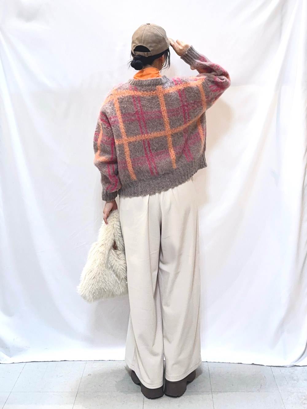 ピンク系のニット/セーター、ホワイト系のその他パンツ、ホワイト系のトートバッグを着用したレディースの秋コーディネートの3枚目の写真