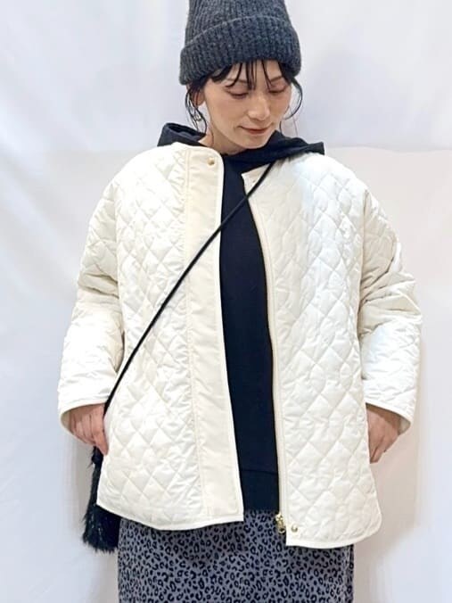 ホワイト系のノーカラージャケット、グレー系のパーカー、グレー系のスカートを着用したレディースの冬コーディネートの6枚目の写真
