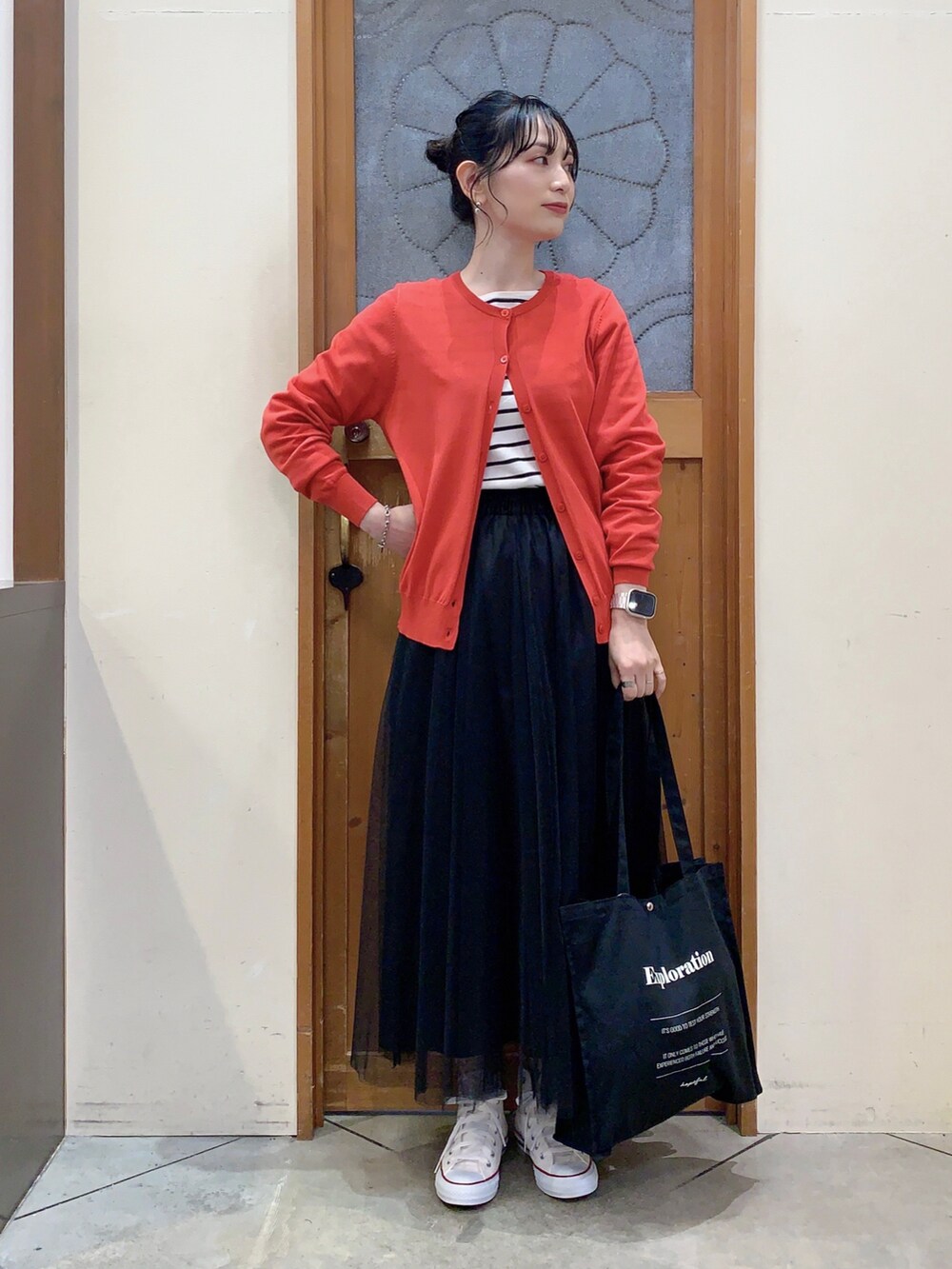 ブラック系のTシャツ/カットソー、レッド系のカーディガン/ボレロ、ブラック系のスカートを着用したレディースの春コーディネートの2枚目の写真