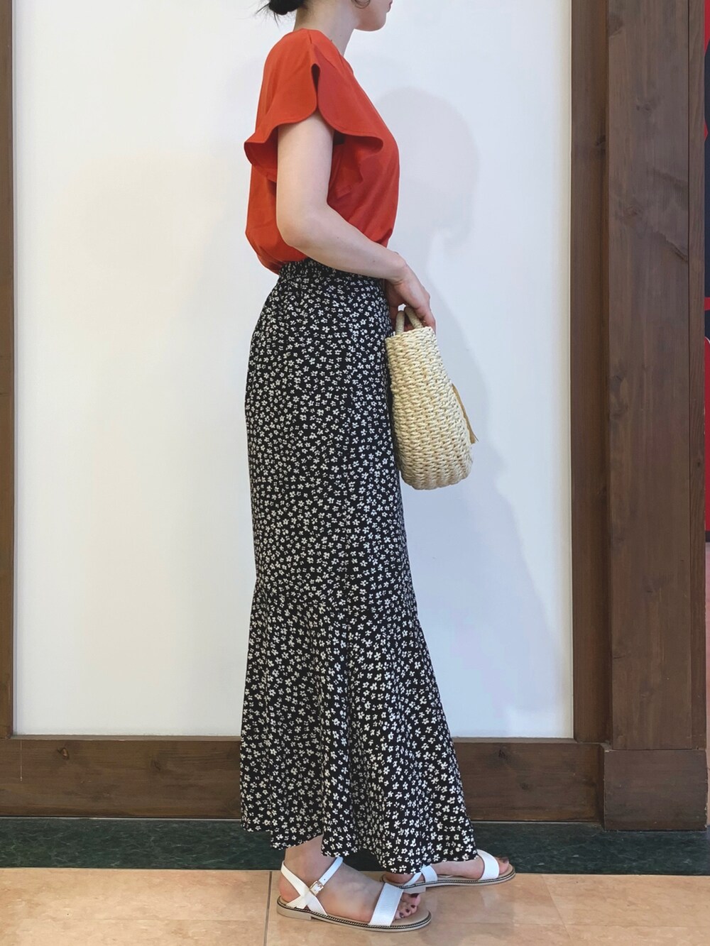 オレンジ系のTシャツ/カットソー、ブラック系のスカート、ホワイト系のショルダーバッグを着用したレディースの夏コーディネートの2枚目の写真