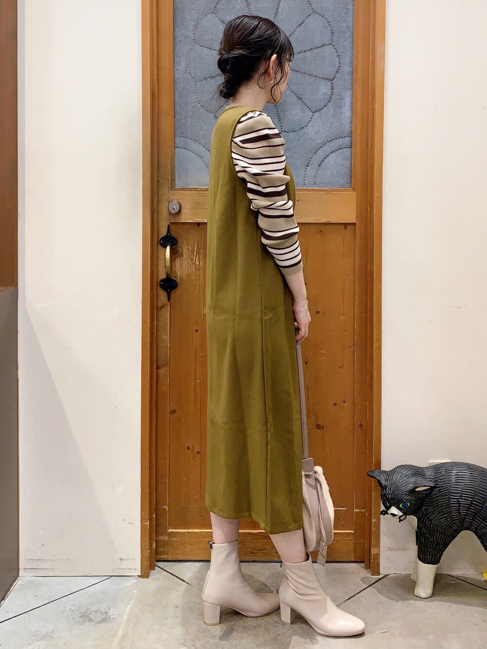 ベージュ系のニット/セーター、イエロー系のスカート、ベージュ系のショルダーバッグを着用したレディースの冬コーディネートの3枚目の写真