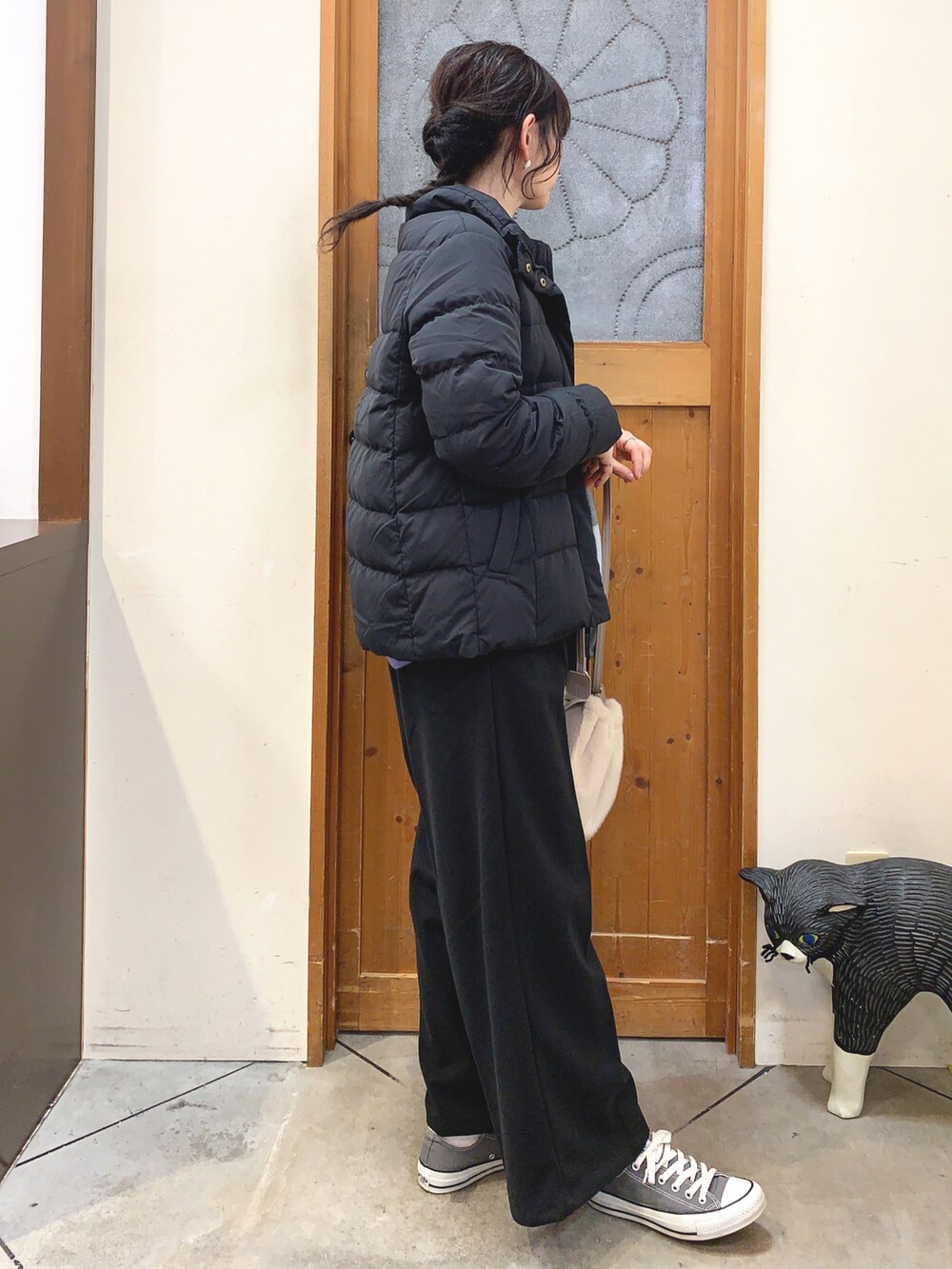 パープル系のニット/セーター、ブラック系のダウンジャケット/コート、ブラック系のその他パンツを着用したレディースの冬コーディネートの3枚目の写真