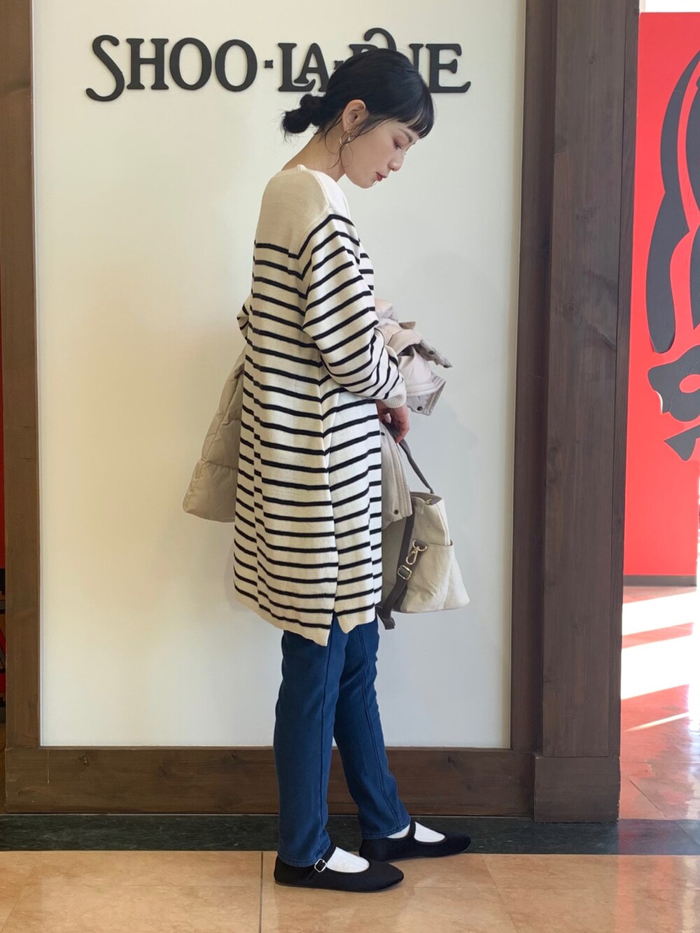 ベージュ系のワンピース、ベージュ系のダウンジャケット/コート、ベージュ系のトートバッグを着用したレディースの冬コーディネートの4枚目の写真