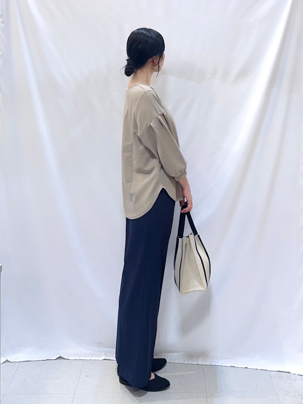 ブルー系のその他パンツ、ブラック系のパンプス、ブラック系のトートバッグを着用したレディースの秋コーディネートの3枚目の写真