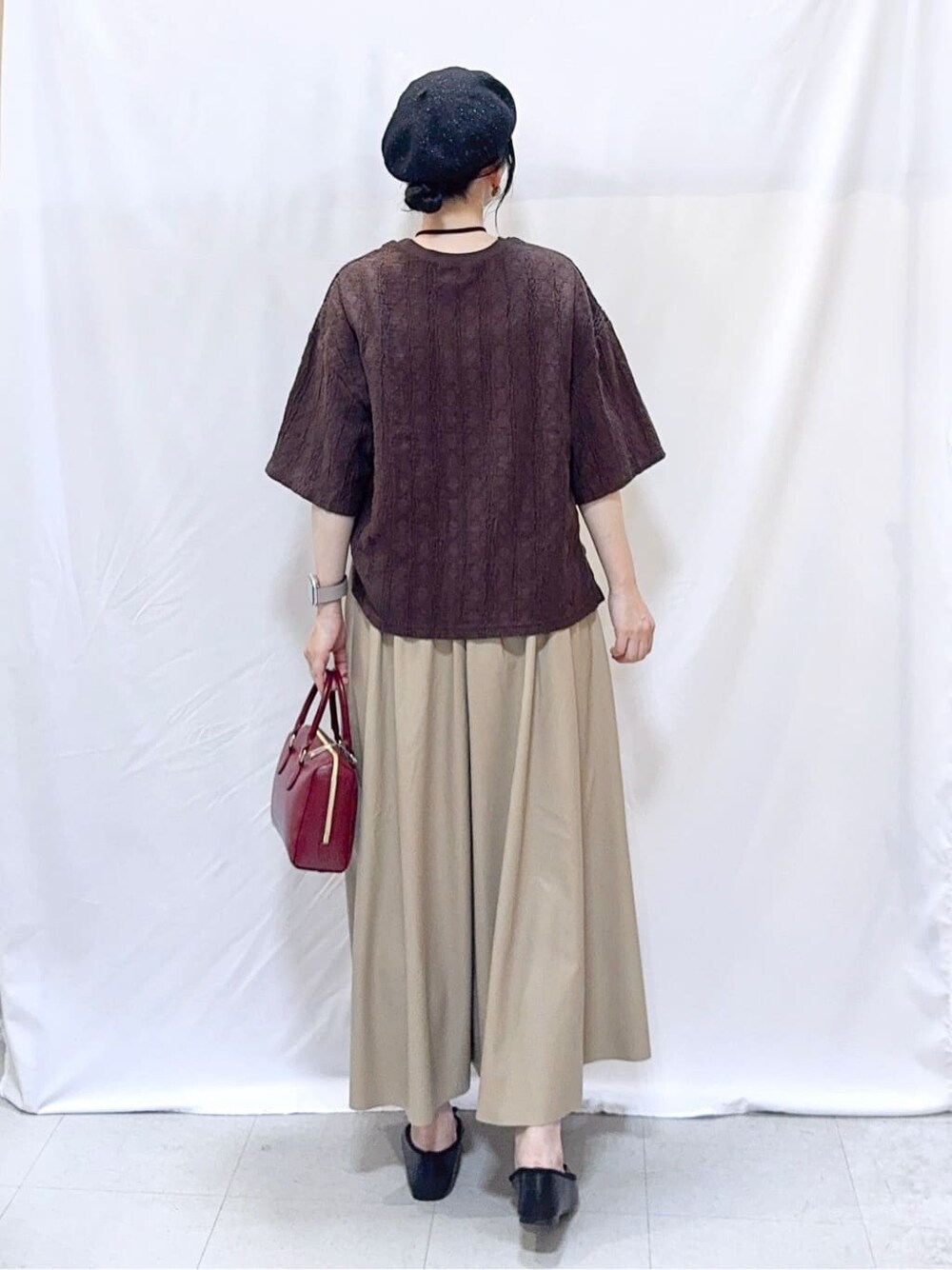 ブラウン系のTシャツ/カットソー、ベージュ系のスカート、ブラック系のその他シューズを着用したレディースの秋コーディネートの4枚目の写真