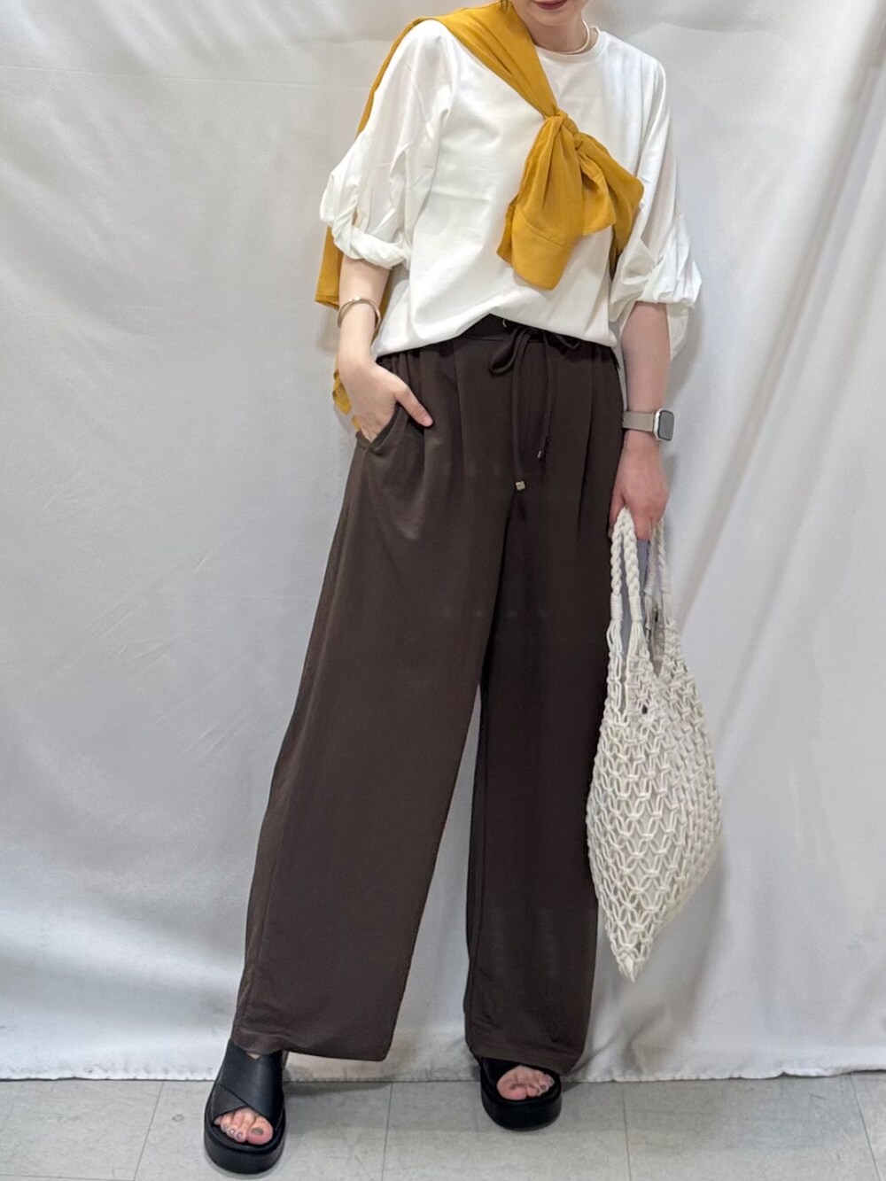 イエロー系のシャツ/ブラウス、ホワイト系のTシャツ/カットソー、ブラウン系のその他パンツを着用したレディースの夏コーディネートの6枚目の写真