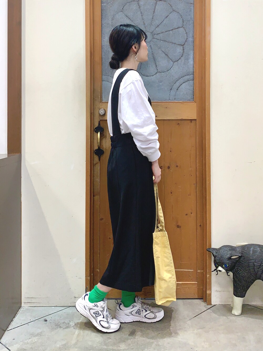 ホワイト系のTシャツ/カットソー、ブラック系のスカート、イエロー系のトートバッグを着用したレディースの春コーディネートの2枚目の写真