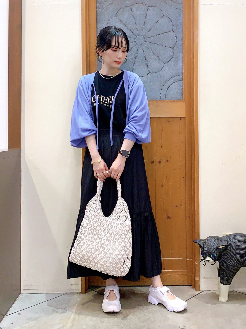 ブラック系のTシャツ/カットソー、ブルー系のカーディガン/ボレロ、ブラック系のスカートを着用したレディースの春コーディネートの2枚目の写真