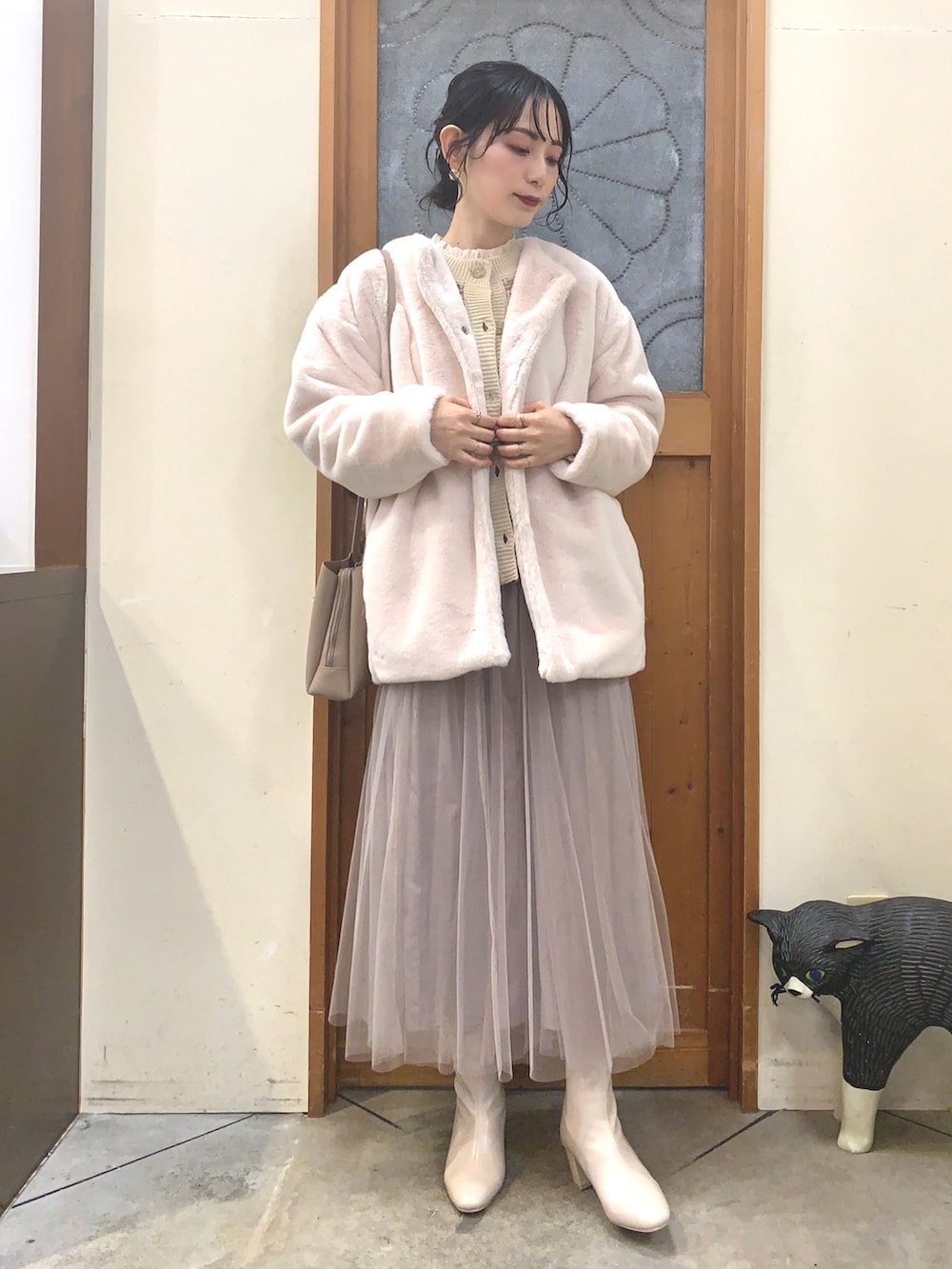 ホワイト系のシャツ/ブラウス、オレンジ系のカーディガン/ボレロ、ベージュ系のブルゾンを着用したレディースの冬コーディネートの2枚目の写真