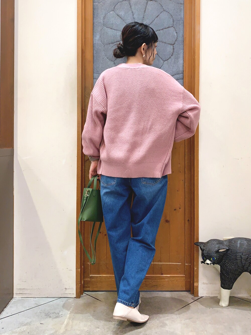 ホワイト系のTシャツ/カットソー、ピンク系のカーディガン/ボレロ、ブルー系のデニムパンツを着用したレディースの冬コーディネートの3枚目の写真