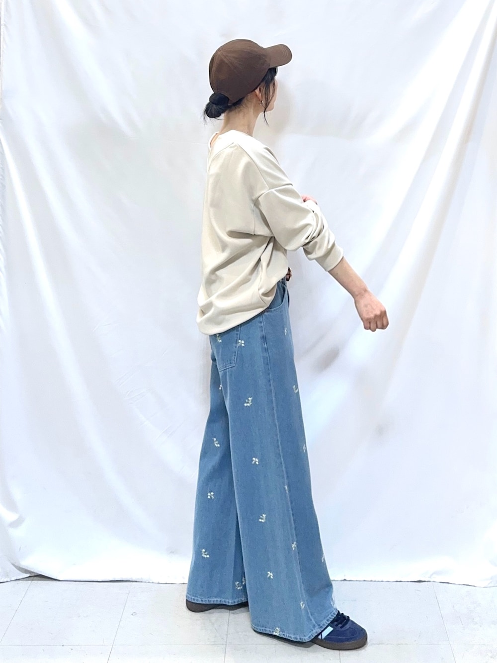 ベージュ系のTシャツ/カットソー、ブルー系のデニムパンツ、イエロー系のベルトを着用したレディースの冬コーディネートの3枚目の写真