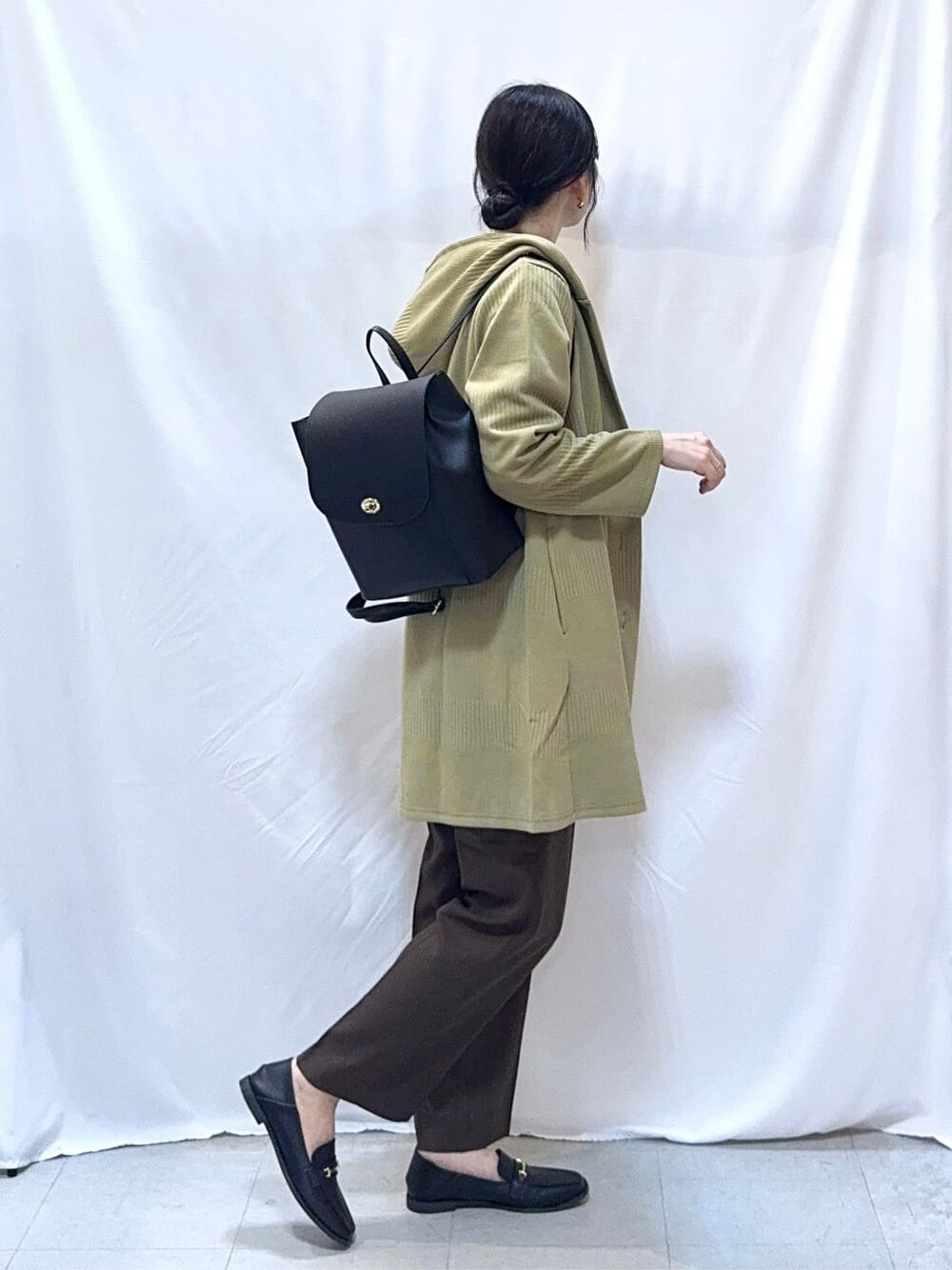 グリーン系のカーディガン/ボレロ、ブラック系のニット/セーター、ブラウン系のその他パンツを着用したレディースの秋コーディネートの4枚目の写真