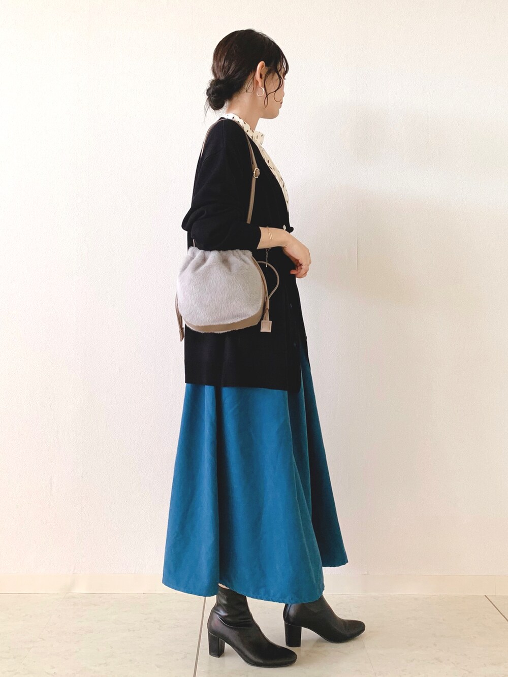 ホワイト系のシャツ/ブラウス、ブラック系のカーディガン/ボレロ、ブルー系のスカートを着用したレディースの秋コーディネートの2枚目の写真
