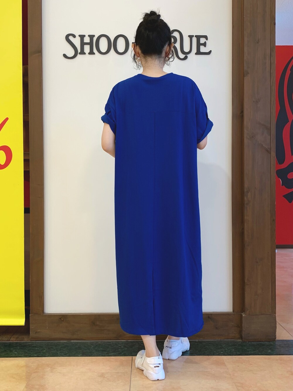 ブルー系のワンピース、ホワイト系のショルダーバッグ、ホワイト系のスニーカーを着用したレディースの夏コーディネートの3枚目の写真