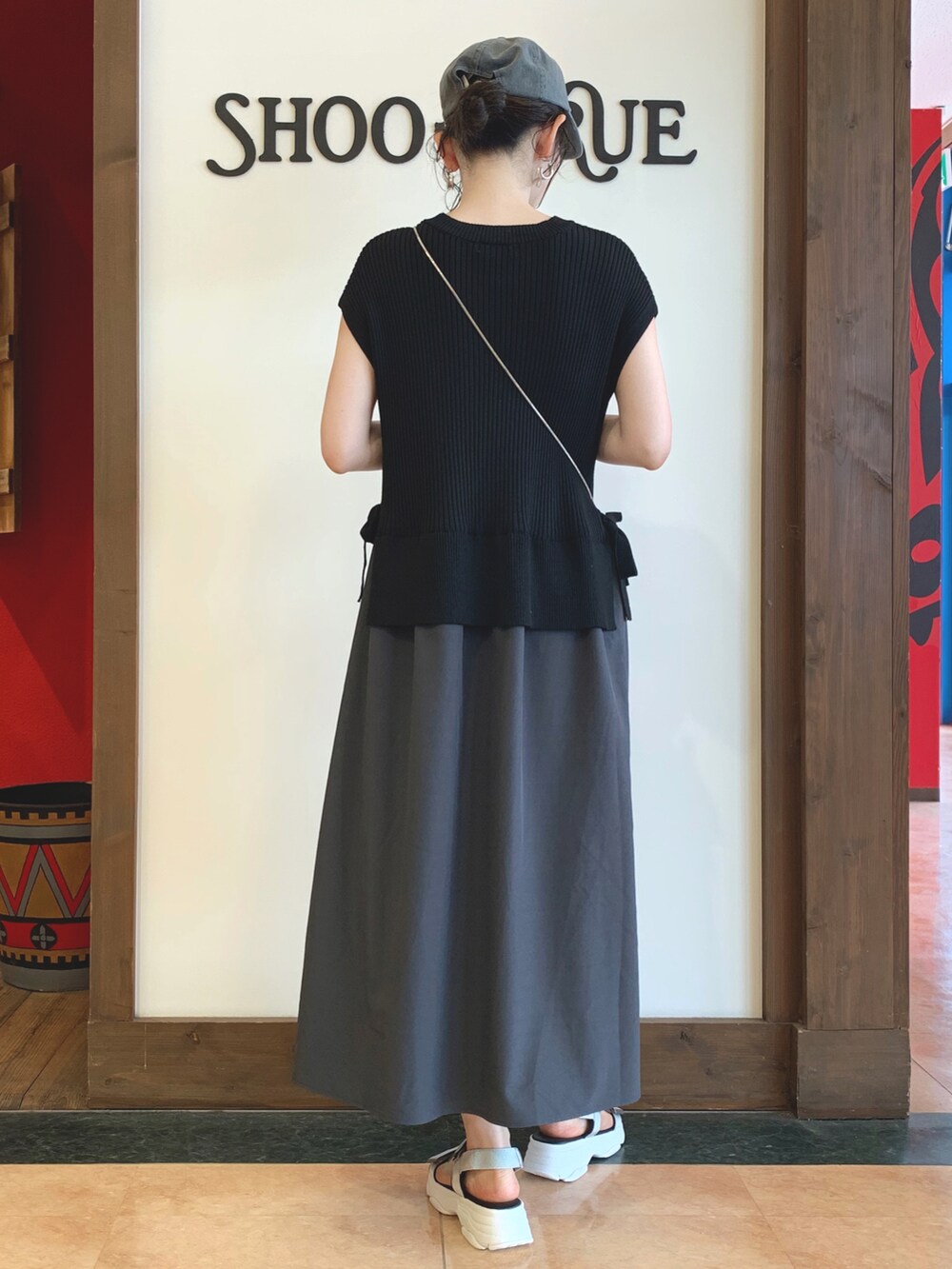 グレー系のワンピース、グレー系のサンダル、シルバー系の財布を着用したレディースの夏コーディネートの2枚目の写真