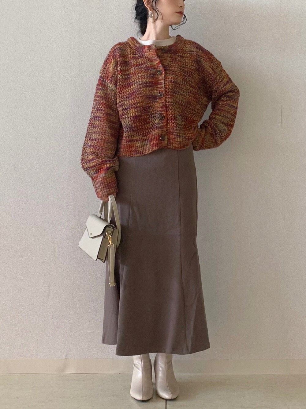 ベージュ系のTシャツ/カットソー、ピンク系のカーディガン/ボレロ、ブラウン系のスカートを着用したレディースの秋コーディネートの4枚目の写真