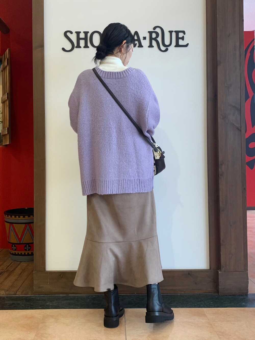 ホワイト系のTシャツ/カットソー、パープル系のカーディガン/ボレロ、ベージュ系のスカートを着用したレディースの冬コーディネートの3枚目の写真