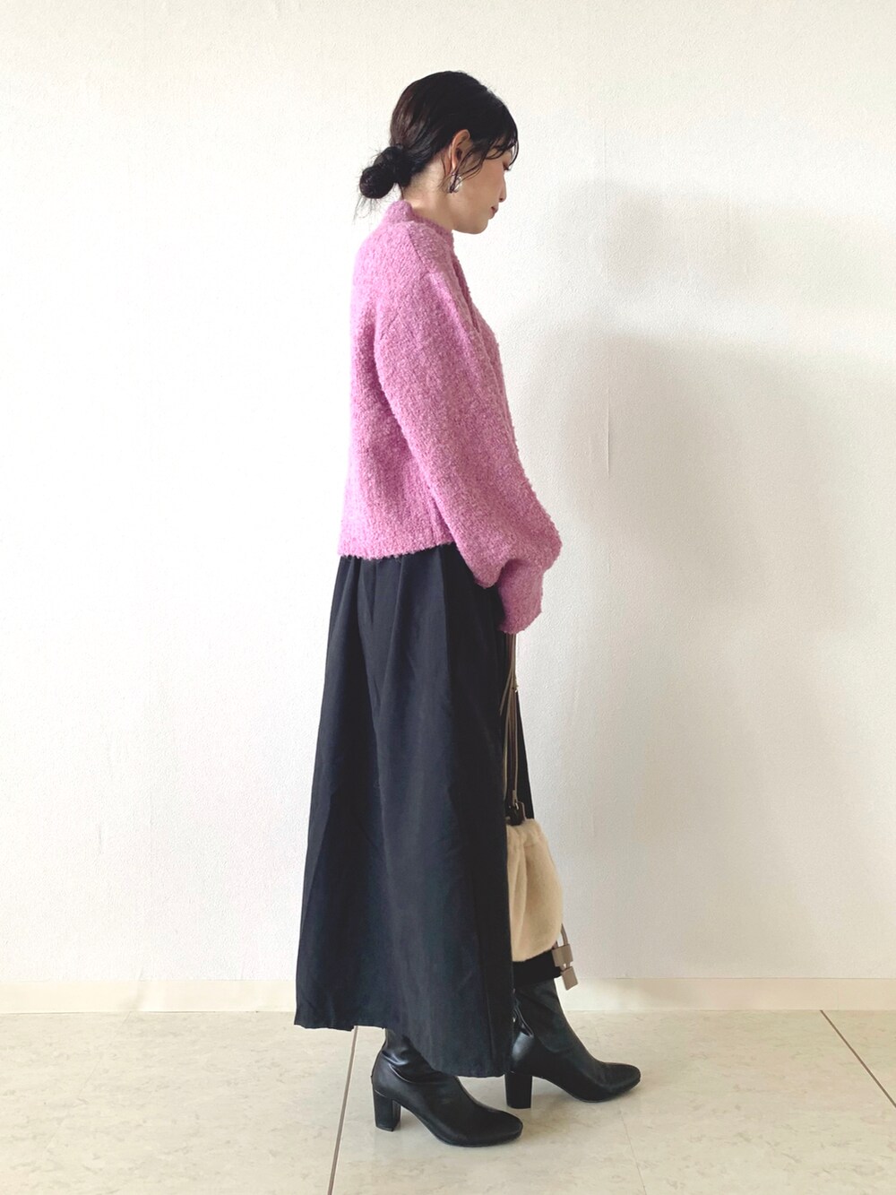 ピンク系のニット/セーター、ブラック系のスカート、ベージュ系のショルダーバッグを着用したレディースの秋コーディネートの2枚目の写真