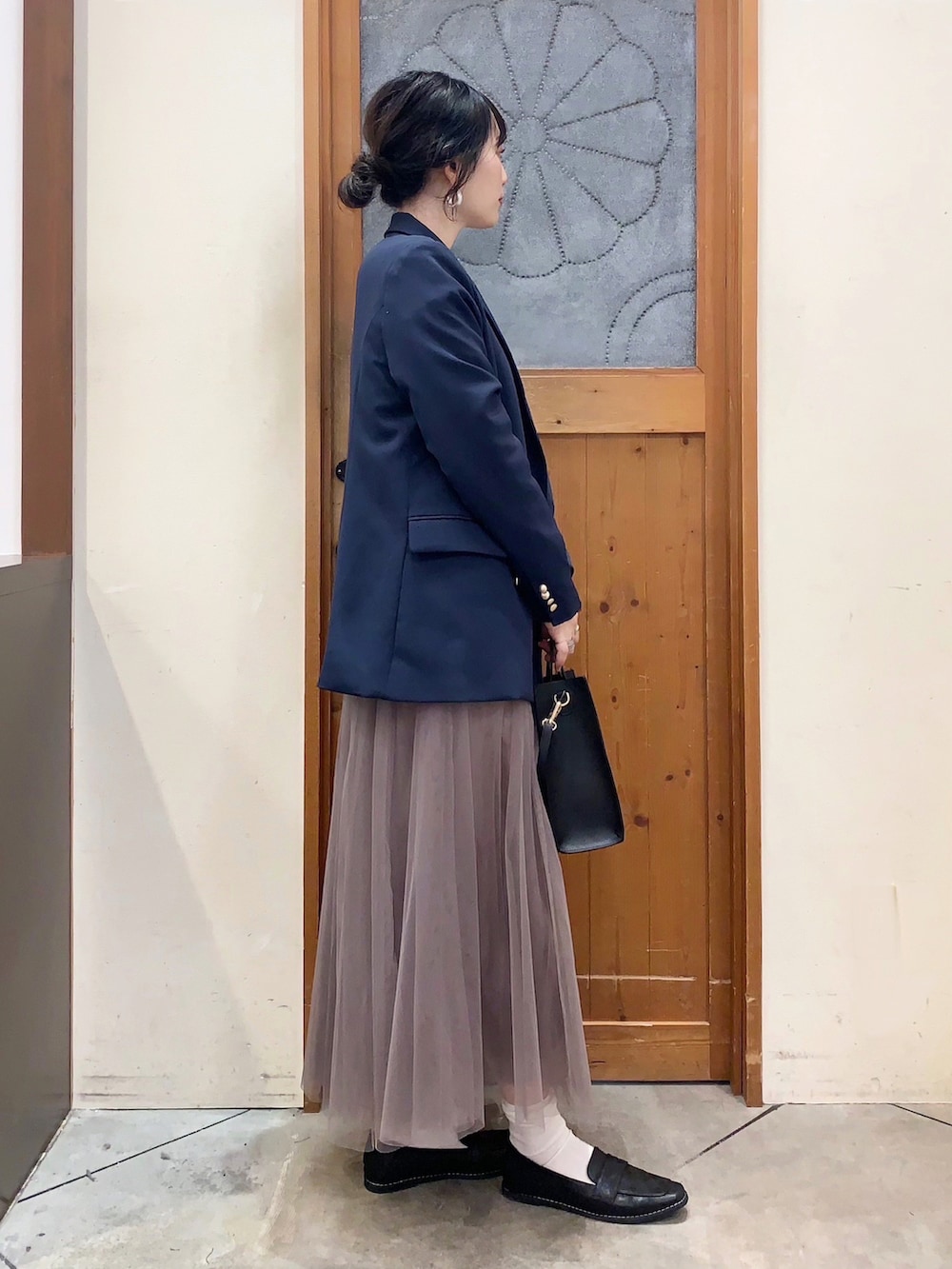 ベージュ系のスウェット、ブルー系のテーラードジャケット、ベージュ系のスカートを着用したレディースの冬コーディネートの3枚目の写真