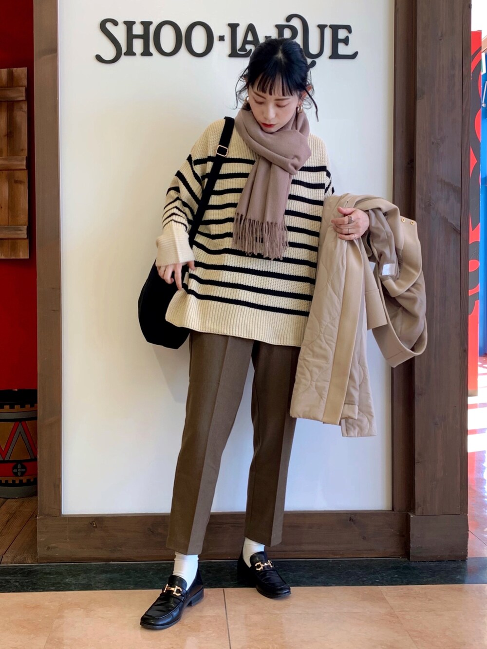 ベージュ系のニット/セーター、ベージュ系のその他アウター、グリーン系のその他パンツを着用したレディースの冬コーディネートの2枚目の写真