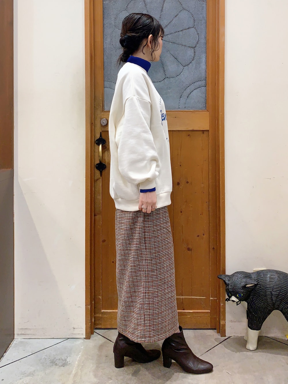 ホワイト系のスウェット、ブルー系のニット/セーター、ベージュ系のスカートを着用したレディースの冬コーディネートの3枚目の写真