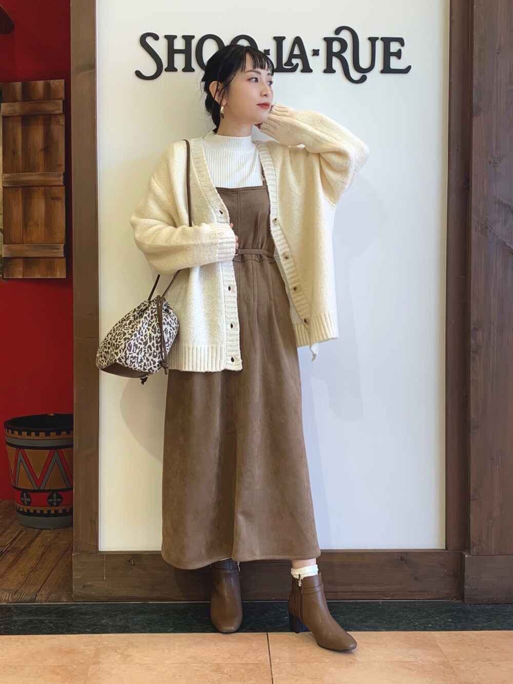 ホワイト系のニット/セーター、ホワイト系のカーディガン/ボレロ、ブラウン系のスカートを着用したレディースの冬コーディネートの2枚目の写真