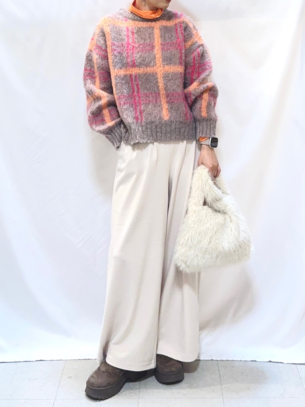 ピンク系のニット/セーター、ホワイト系のその他パンツ、ホワイト系のトートバッグを着用したレディースの秋コーディネートの4枚目の写真