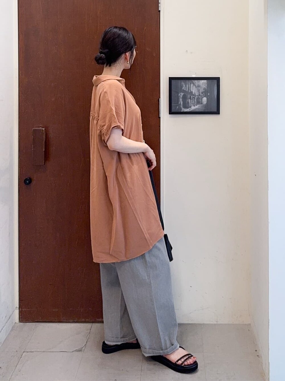 オレンジ系のチュニック、ブラック系のタンクトップ、グレー系のその他パンツを着用したレディースの夏コーディネートの3枚目の写真
