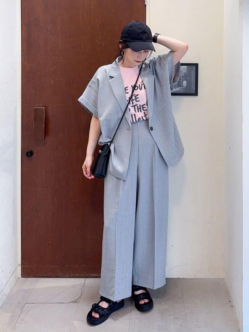 グレー系のテーラードジャケット、ピンク系のTシャツ/カットソー、グレー系のその他パンツを着用したレディースの春コーディネートの2枚目の写真