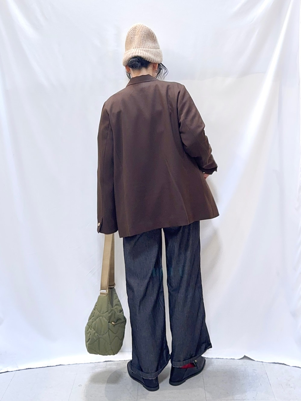 ブラウン系のテーラードジャケット、グレー系のニット/セーター、ブラック系のサロペット/オーバーオールを着用したレディースの秋コーディネートの5枚目の写真