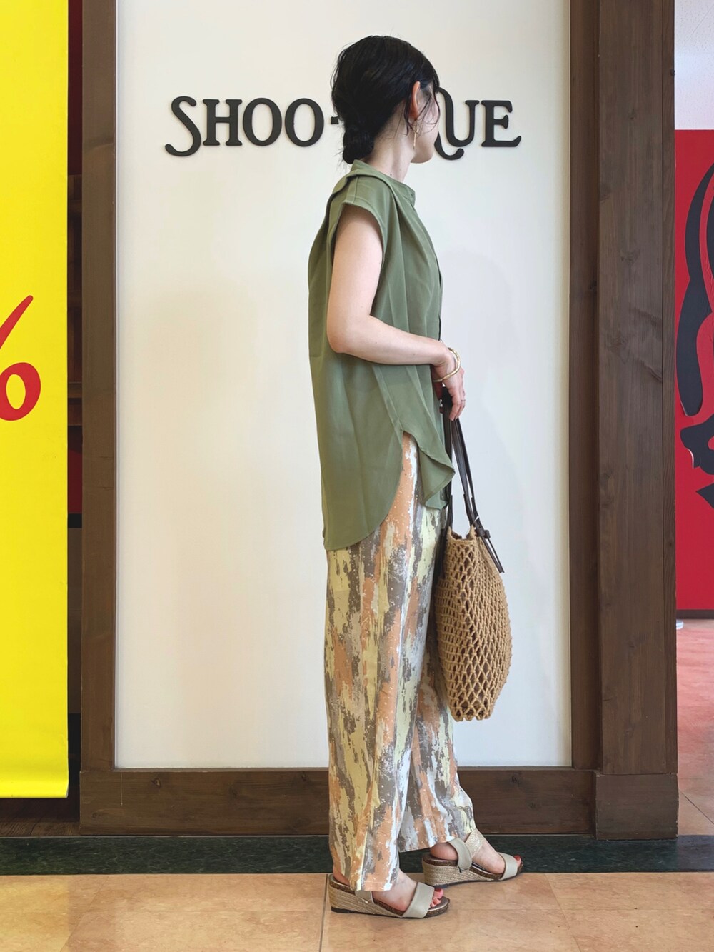 グリーン系のシャツ/ブラウス、レッド系のその他パンツ、ブラウン系のトートバッグを着用したレディースの夏コーディネートの2枚目の写真