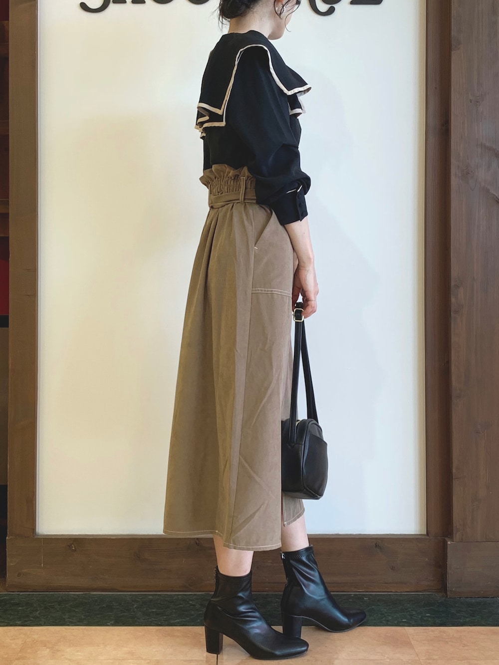 ブラック系のシャツ/ブラウス、ベージュ系のスカート、ブラック系のショルダーバッグを着用したレディースの夏コーディネートの2枚目の写真