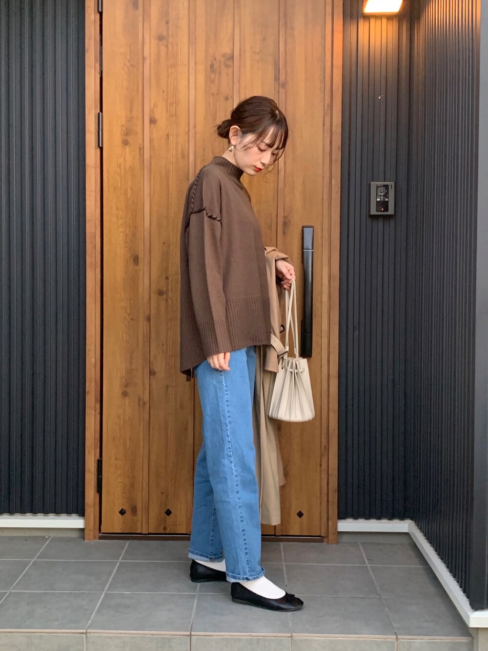 ブラウン系のニット/セーター、ブルー系のデニムパンツを着用したレディースの秋コーディネートの4枚目の写真