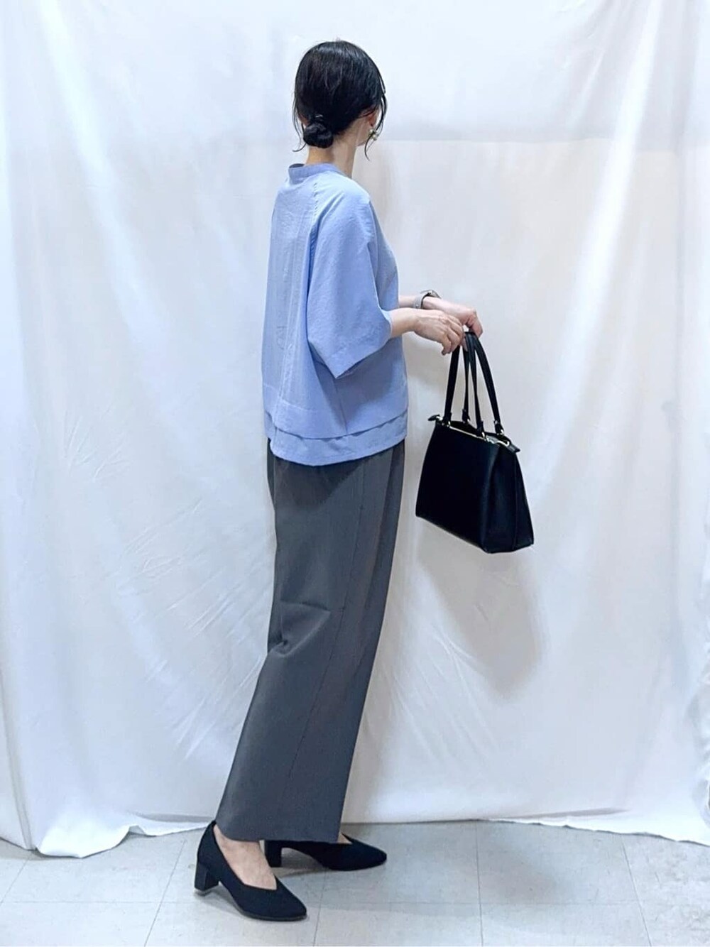 ブルー系のシャツ/ブラウス、グレー系のその他パンツ、ブラック系のパンプスを着用したレディースの秋コーディネートの3枚目の写真