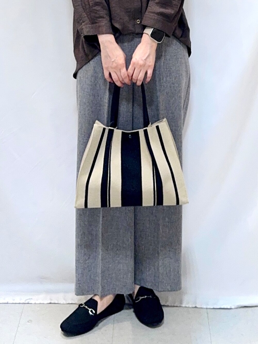 グレー系のその他パンツ、ブラック系のその他シューズ、ブラック系のトートバッグを着用したレディースの秋コーディネートの7枚目の写真