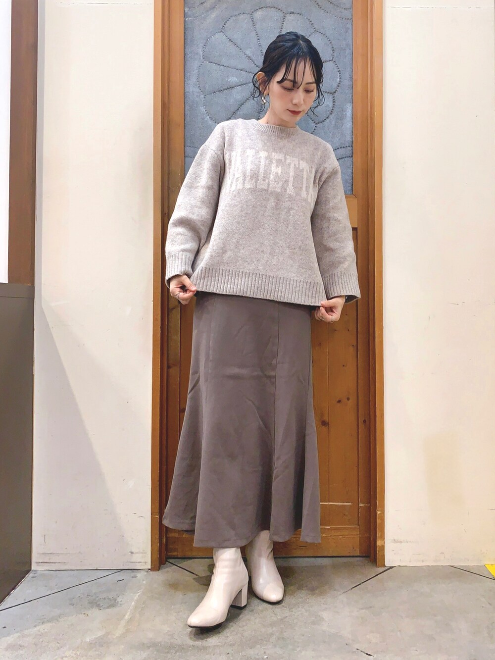 ベージュ系のブルゾン、ベージュ系のニット/セーター、ブラウン系のスカートを着用したレディースの秋コーディネートの4枚目の写真