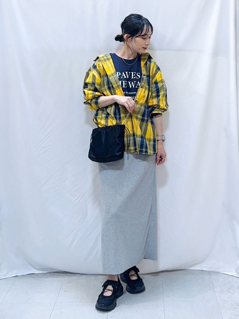 イエロー系のシャツ/ブラウス、ブルー系のTシャツ/カットソー、グレー系のスカートを着用したレディースの秋コーディネートの2枚目の写真