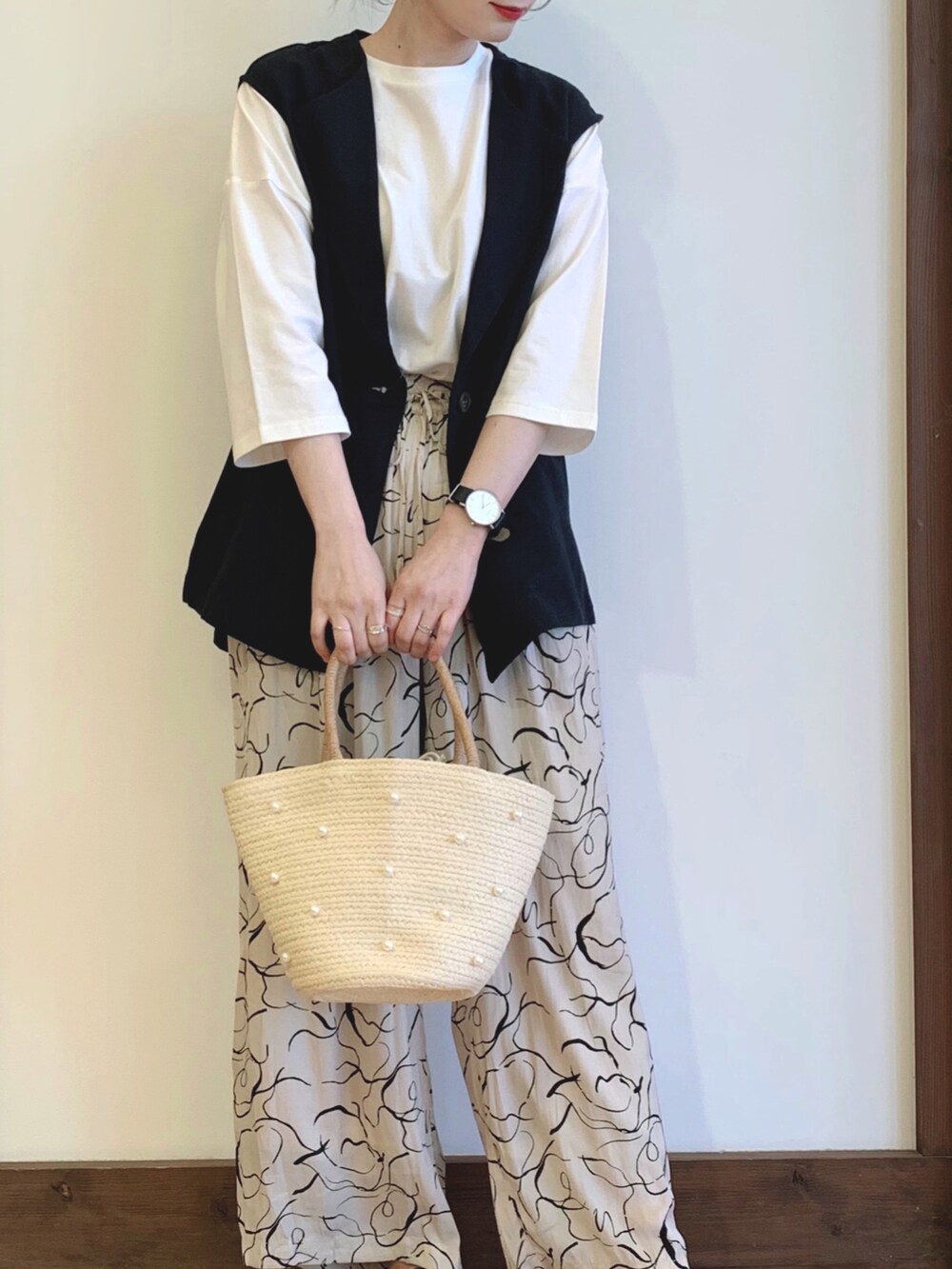 ブラック系のベスト、ホワイト系のTシャツ/カットソー、ベージュ系のその他パンツを着用したレディースの春コーディネートの2枚目の写真