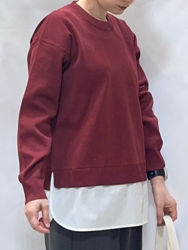 レッド系のニット/セーター、グレー系のその他パンツ、ブラック系のブーツを着用したレディースの秋コーディネートの6枚目の写真