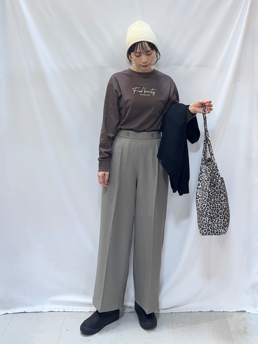 ブラウン系のTシャツ/カットソー、ベージュ系のその他パンツ、ブラック系のブーツを着用したレディースの秋コーディネートの6枚目の写真