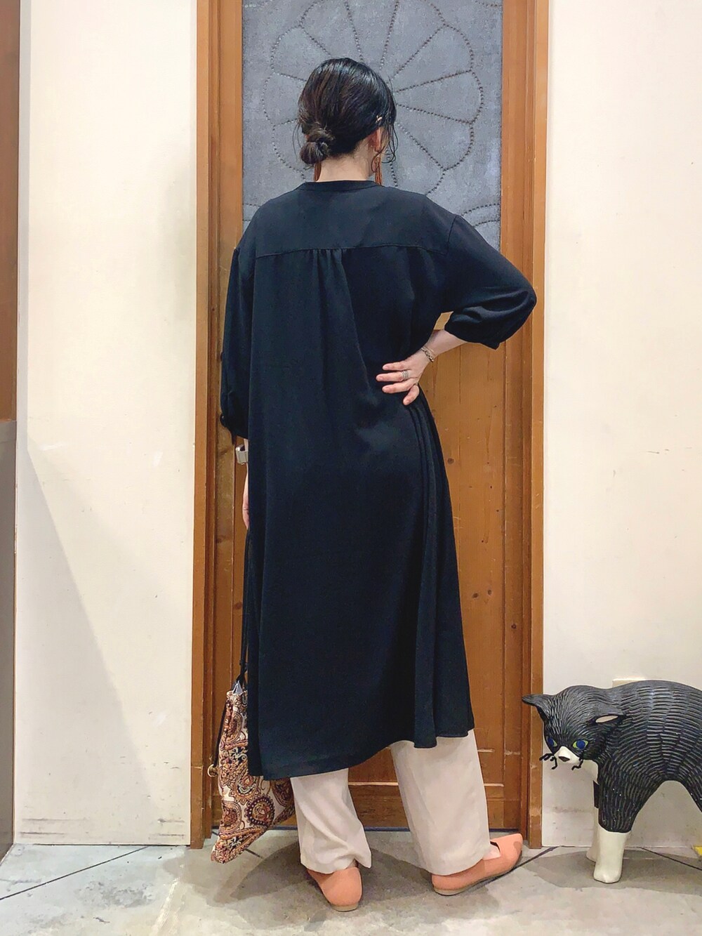 ブラック系のワンピース、ベージュ系のトートバッグ、オレンジ系のパンプスを着用したレディースの春コーディネートの4枚目の写真