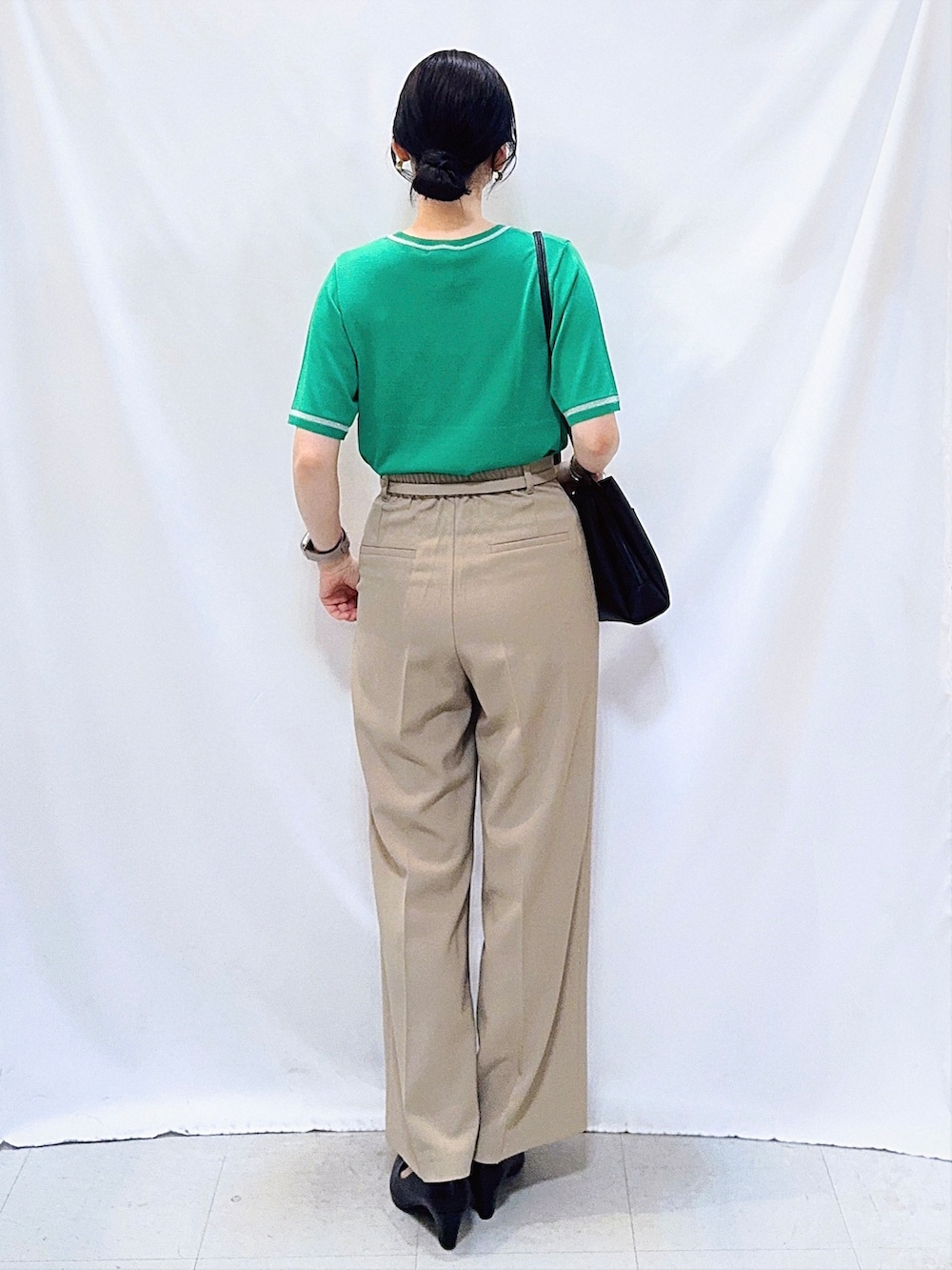 グリーン系のニット/セーター、ベージュ系のその他パンツ、ブラック系のパンプスを着用したレディースの夏コーディネートの4枚目の写真