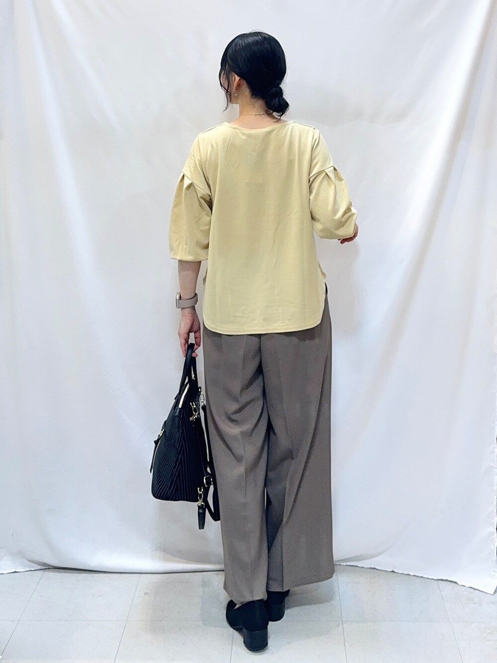 ブラウン系のその他パンツ、ブラック系のパンプス、ブラック系のバックパック/リュックを着用したレディースの秋コーディネートの3枚目の写真