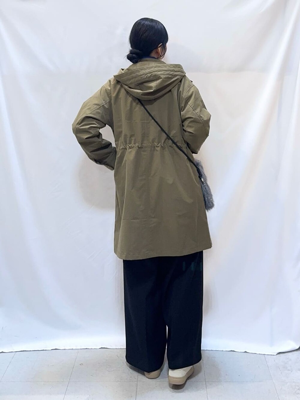 グリーン系のミリタリージャケット、グレー系のニット/セーター、ブルー系のニット/セーターを着用したレディースの冬コーディネートの3枚目の写真