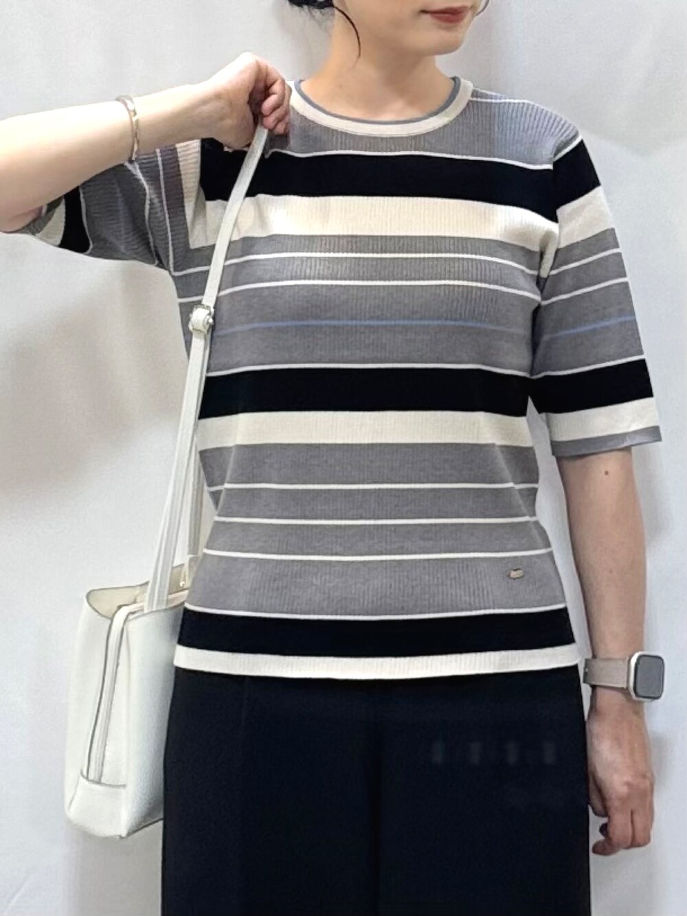 グレー系のニット/セーター、ブラック系のその他パンツ、ブラック系のサンダルを着用したレディースの夏コーディネートの6枚目の写真