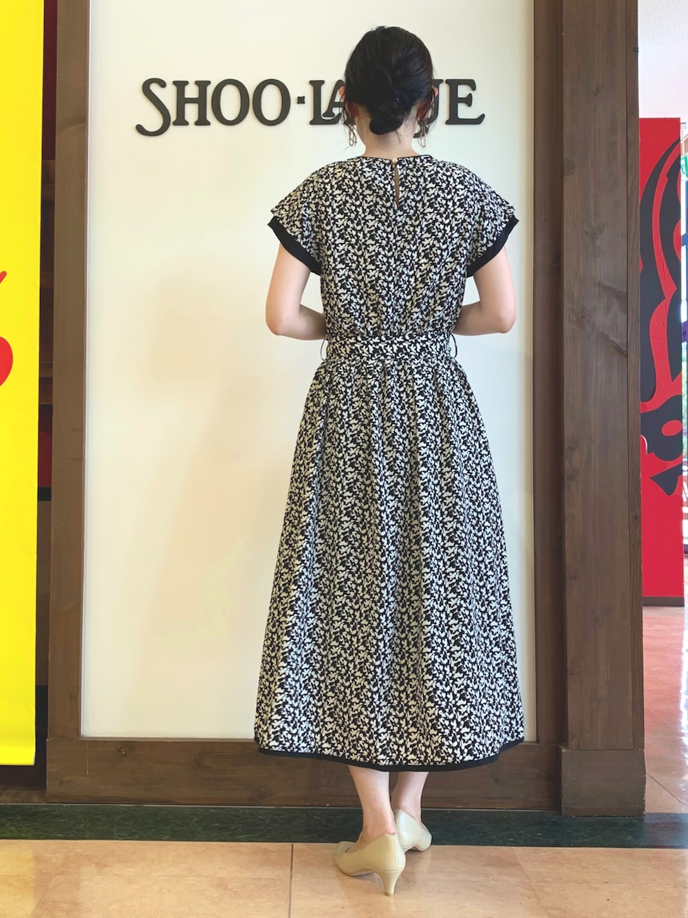 ブラック系のワンピース、ホワイト系のトートバッグ、ベージュ系のパンプスを着用したレディースの夏コーディネートの3枚目の写真