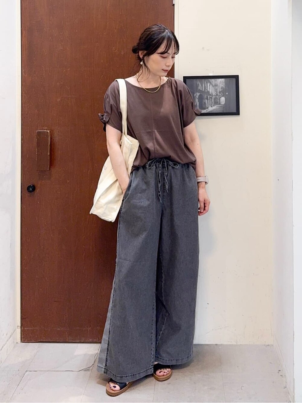 ベージュ系のベスト、ブラウン系のTシャツ/カットソー、ブラック系のデニムパンツを着用したレディースの夏コーディネートの6枚目の写真