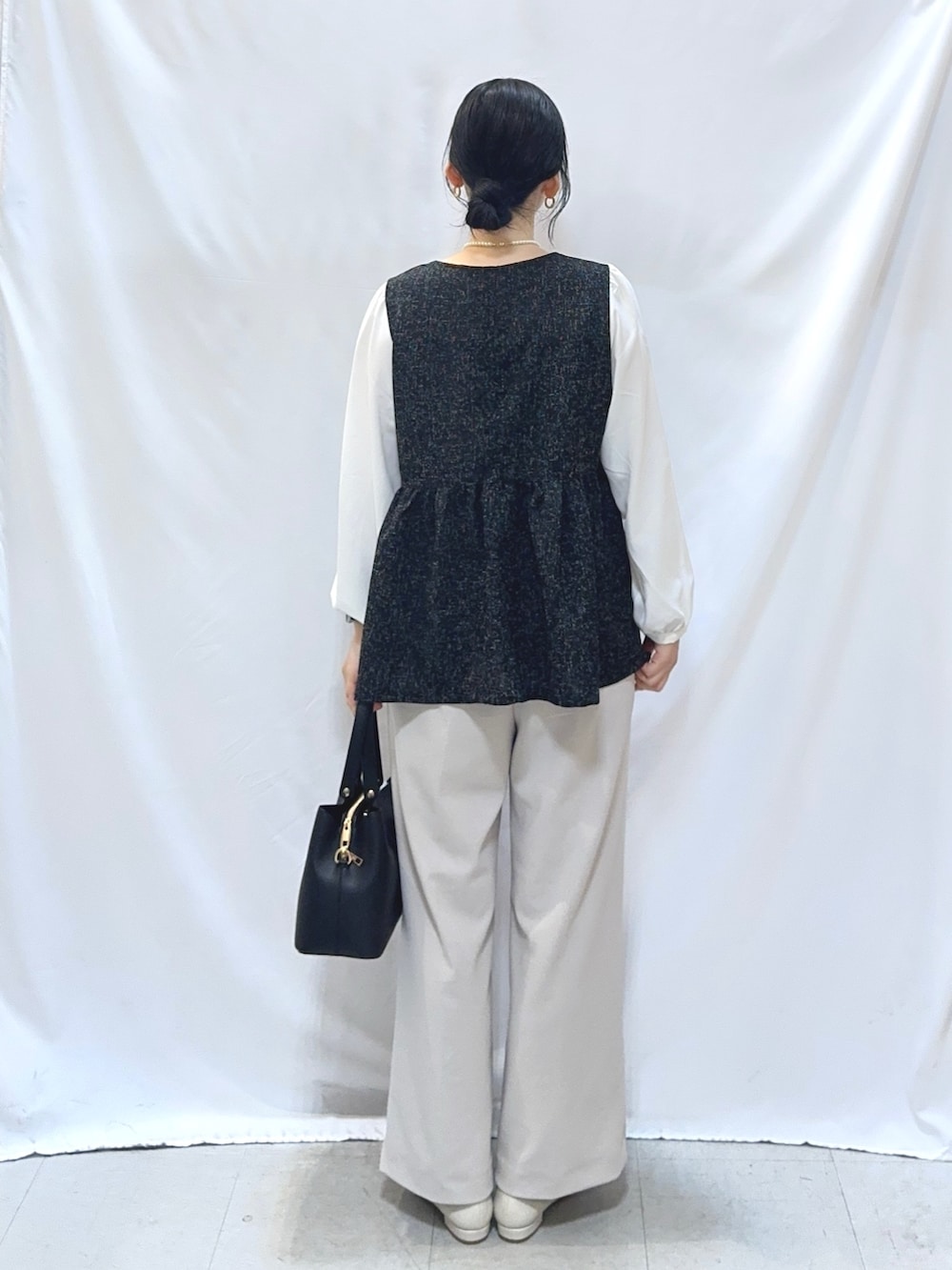 ブラック系のシャツ/ブラウス、ベージュ系のその他パンツ、ホワイト系のパンプスを着用したレディースの冬コーディネートの4枚目の写真